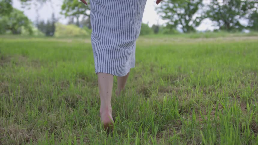 A woman walks through the tall grass