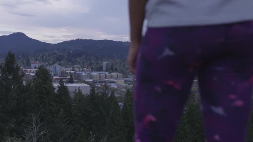 Girl looks at the view of the town at dusk