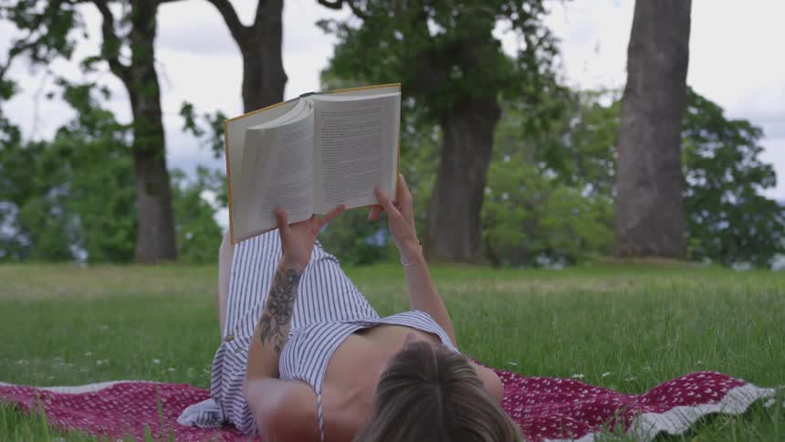 Girl laying in park reading a book