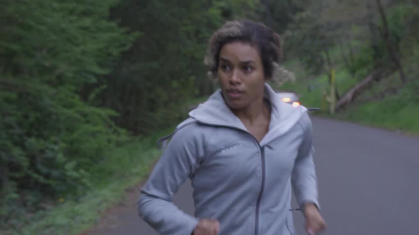 Woman runs uphill on a road