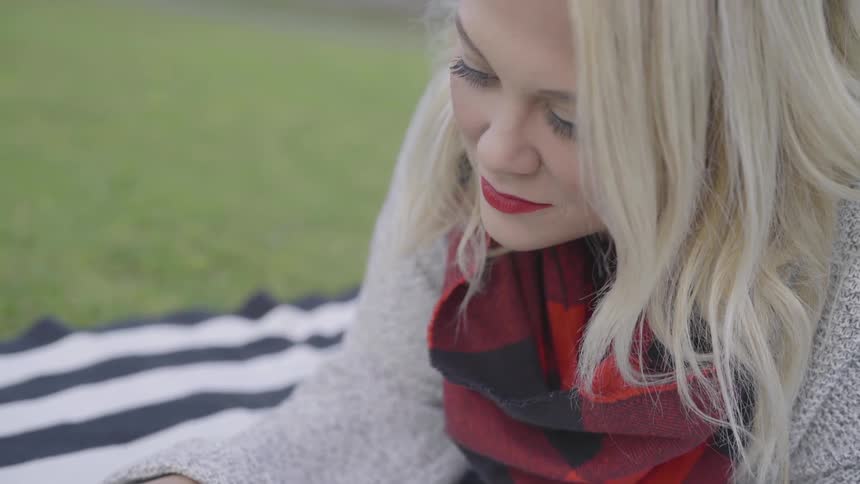 Woman lays face down on towel in grass