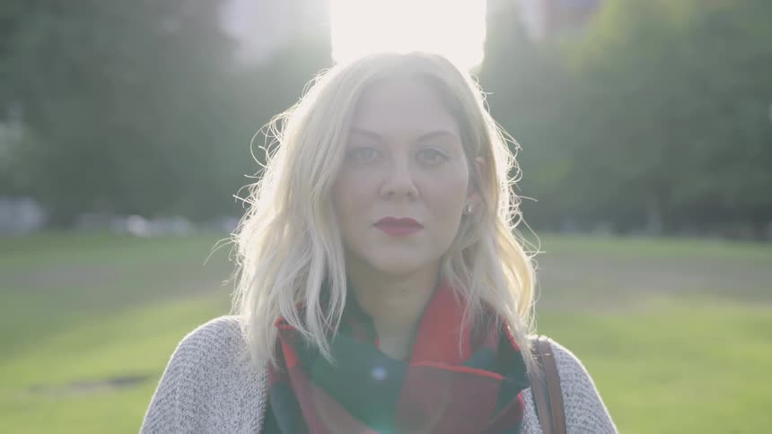 A young white woman turns her head and stares