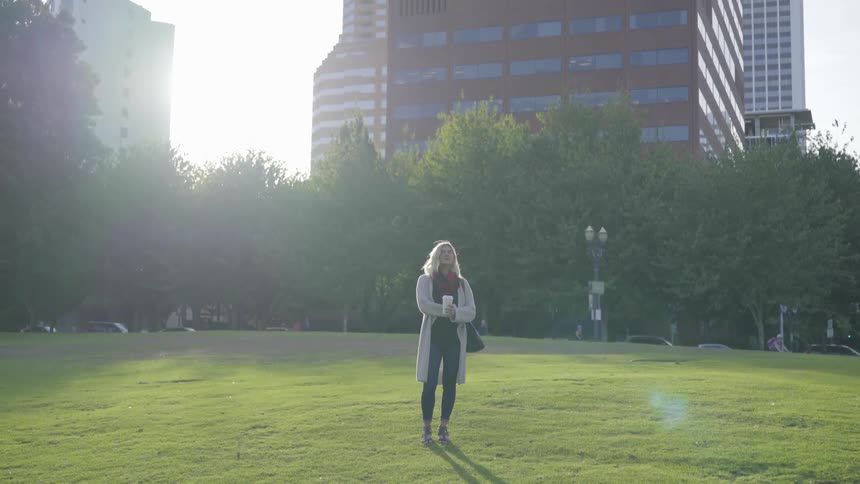 A woman standing in the middle of a field in a park