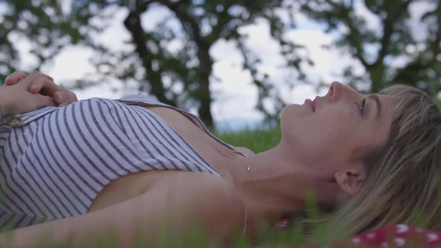 Woman lays in the grass looking skyward