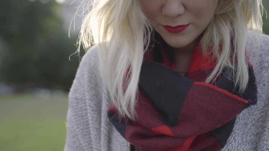 Woman with winter clothes on looking down