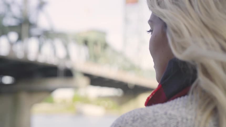 Woman looks out at a bridge