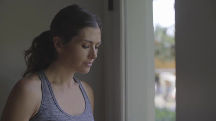Woman stands near window