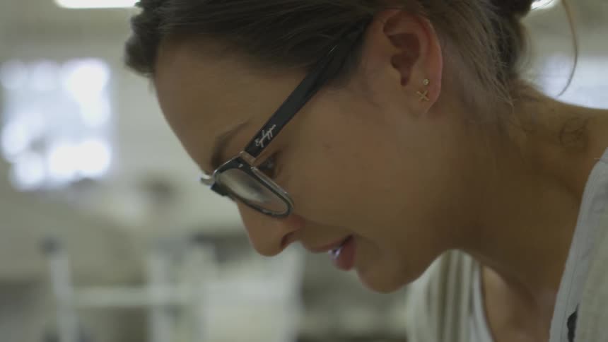 Woman looks down intently in workshop