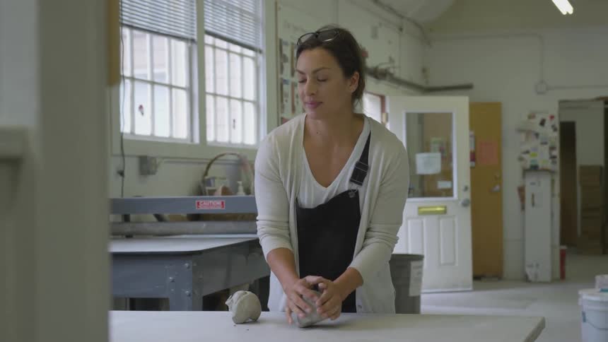 Woman works with the clay in a workshop