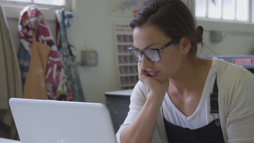 A woman stares at a laptop