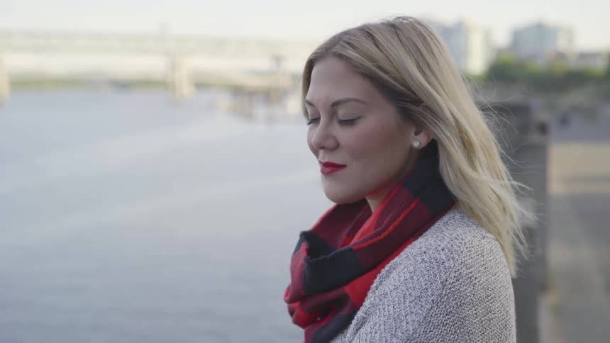 Woman wearing a black and red scarf sits in the breeze