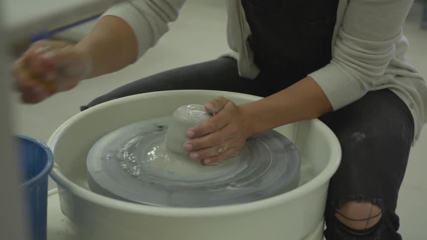 Woman works with potters wheel