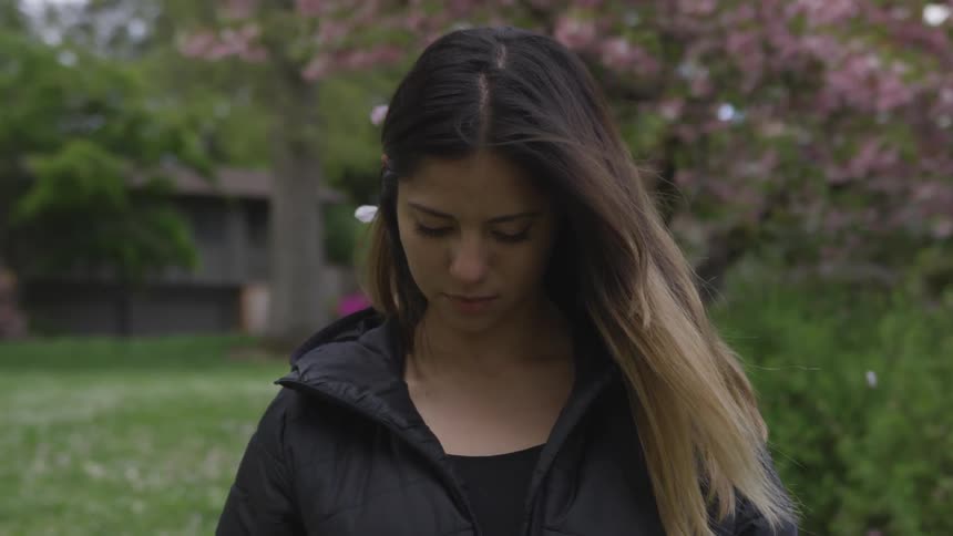 A woman is looking down outdoors