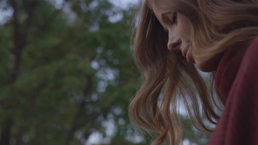 A woman stares downward