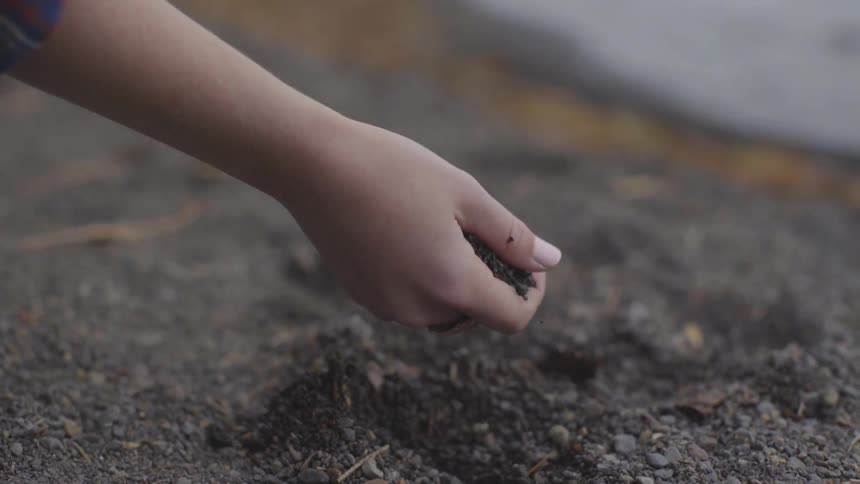 Female picking up gravel from the ground