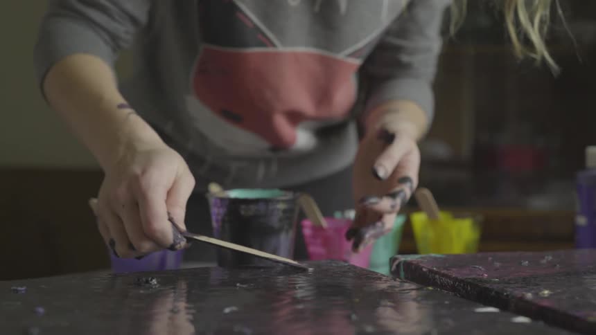 Woman coats surface with paint