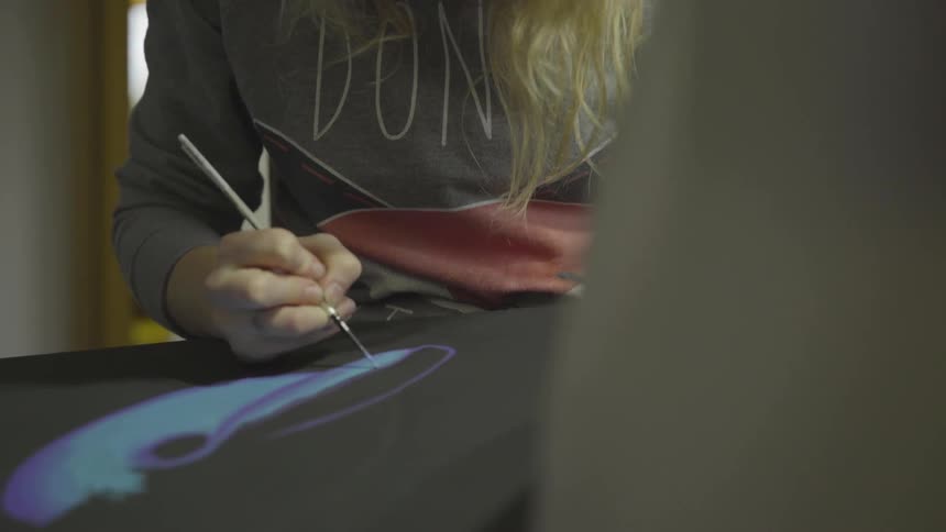 Woman paints on a canvas