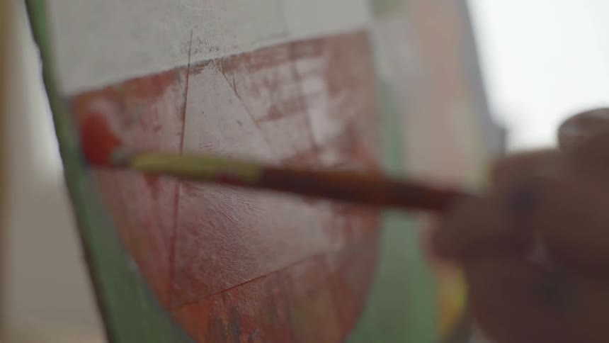 A person painting a picture on a canvas at daytime