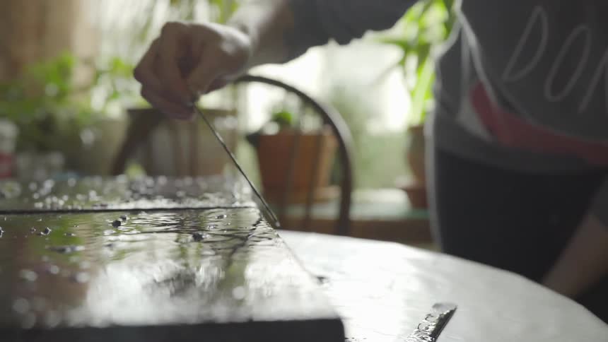 An artist using a stick to paint