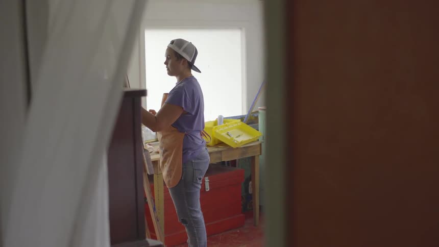 A woman paints on an easel