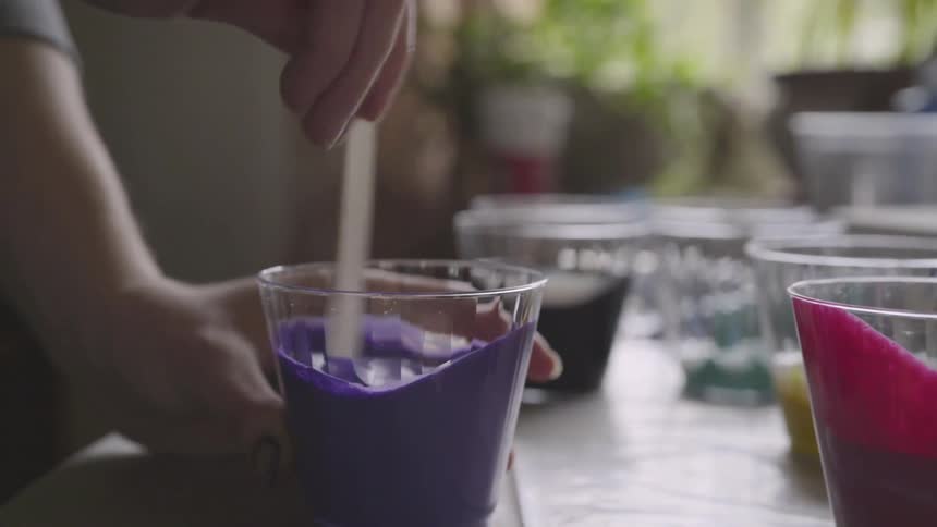 Person stirs a cup of paint