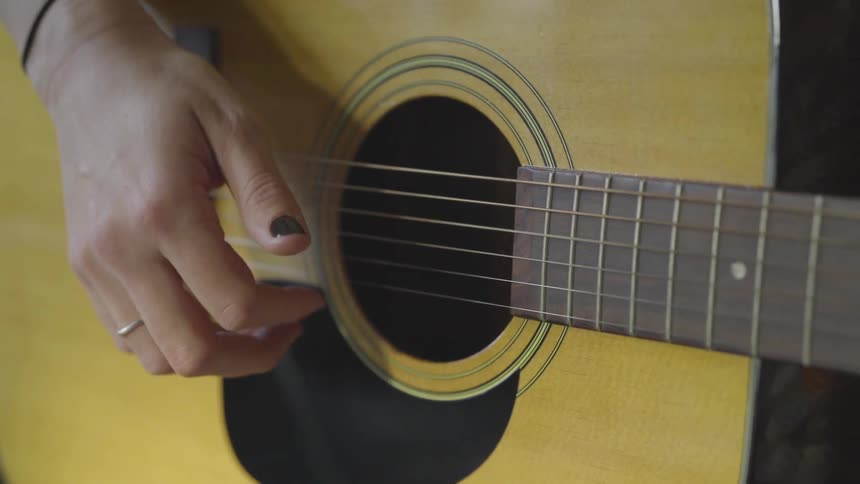 Close up of a woman playing the guitar