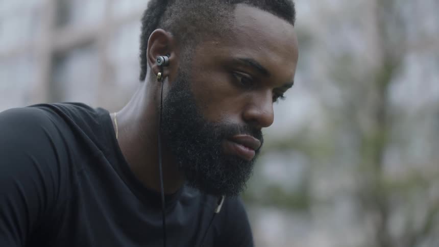A man listens to music while holding a basketball