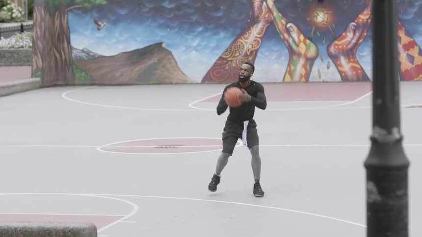 A man throws a basketball into the hoop and misses