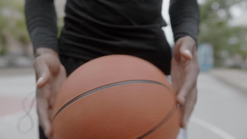 Black man playing around with a basketball