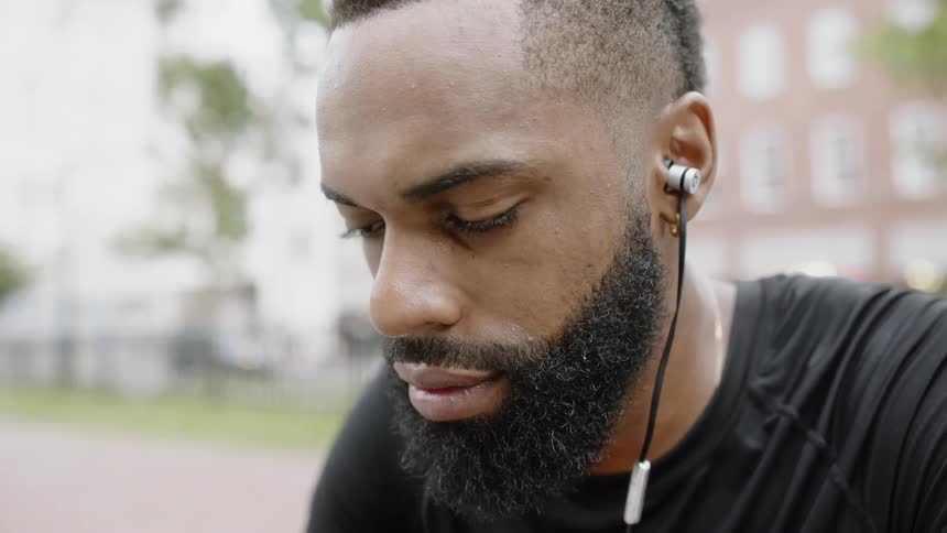 A man sitting outside listening to music