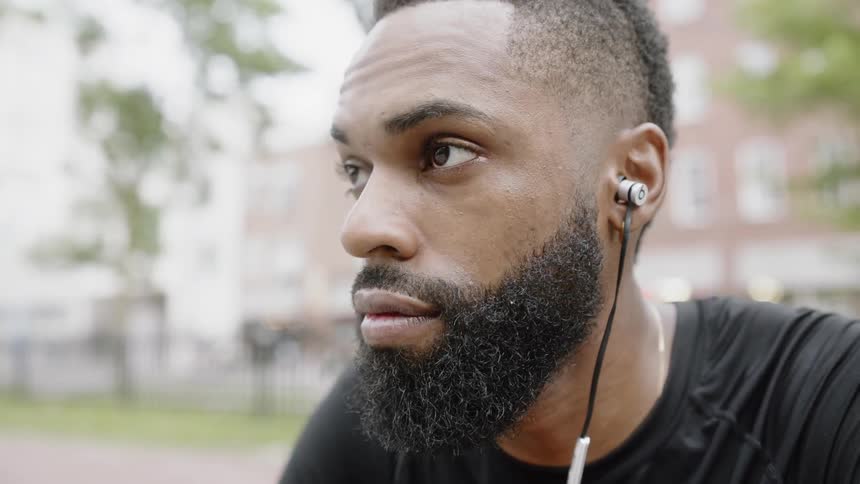 Man sitting on a park listening to music on headphones