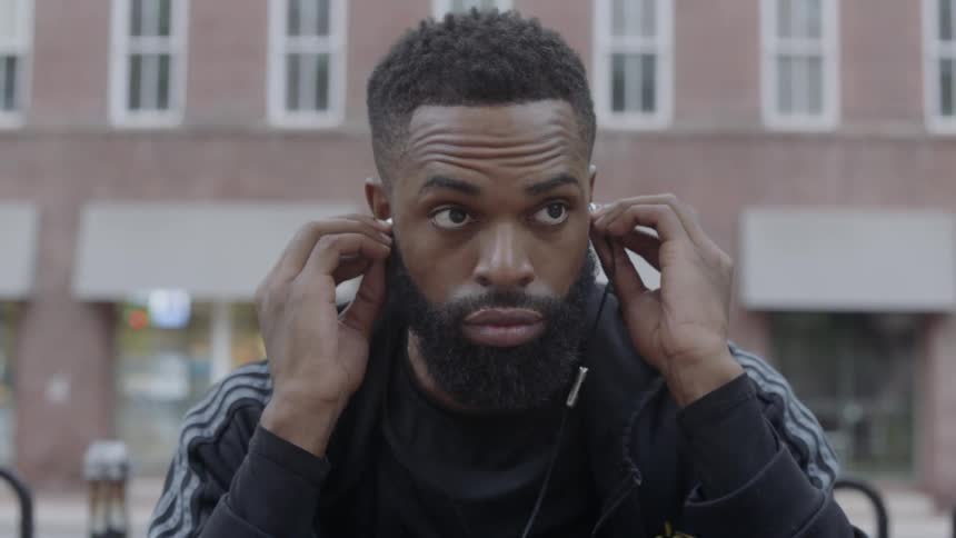 A man puts his headphones in his ears