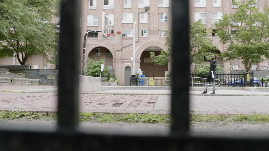 Man playing basketball on court in city