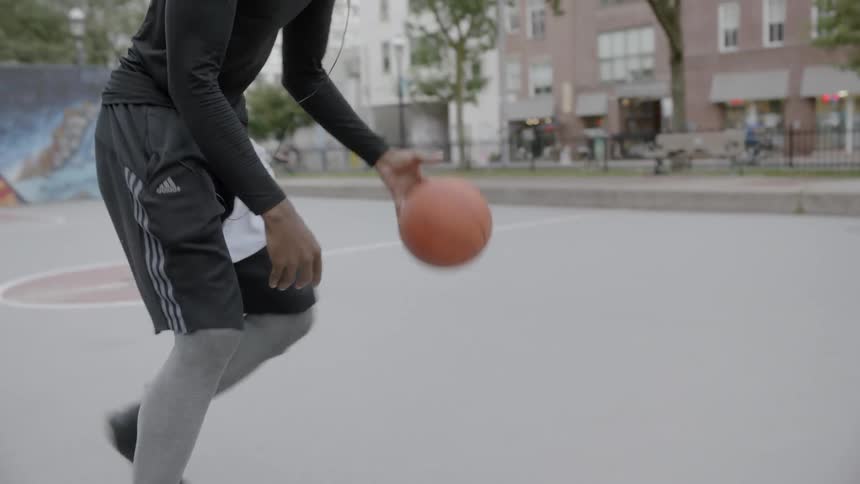 Man playing basketball on an outdoor court
