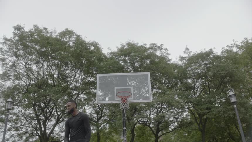 Man stands in front of a basketball court