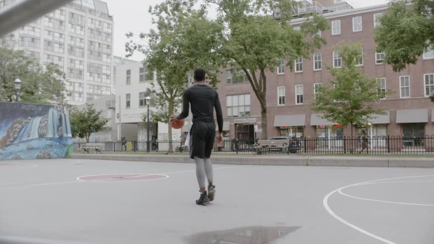 Man dribbles a basketball on a court