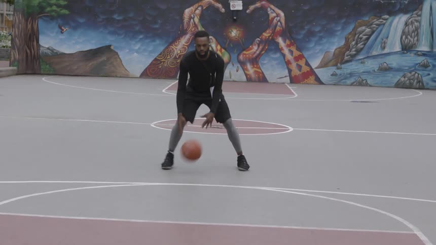 African american man dribbles basketball on outdoor court