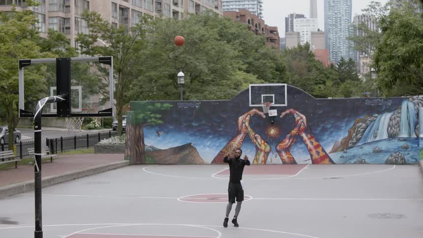 A man plays basketball at an outside court