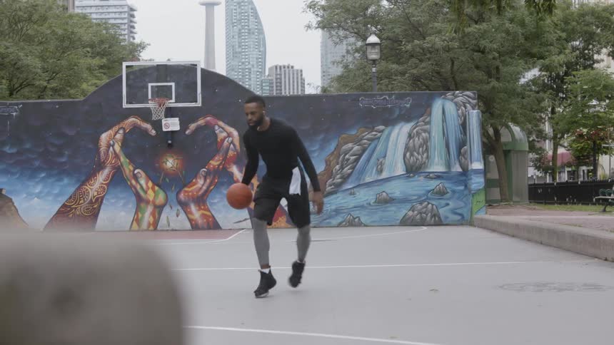 A man dribbles a basketball and shoots