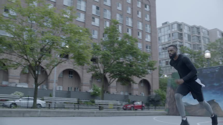 A man doing exercise drills on a outdoor basketball court