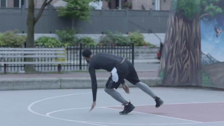 A black man runs back and forth on a basketball court