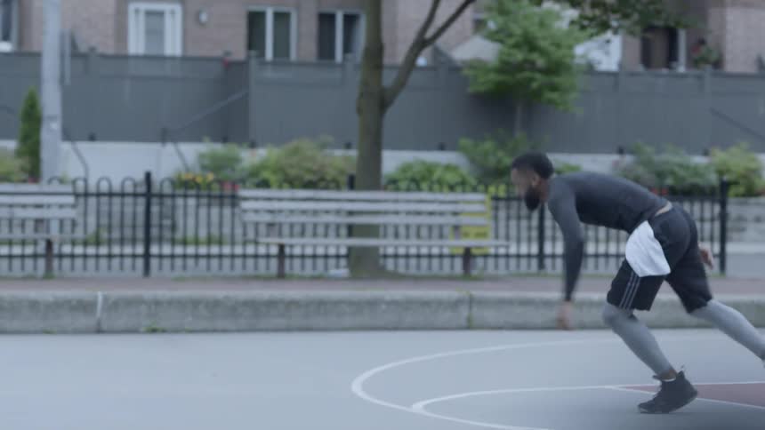 Man training on a basketball court on a public park