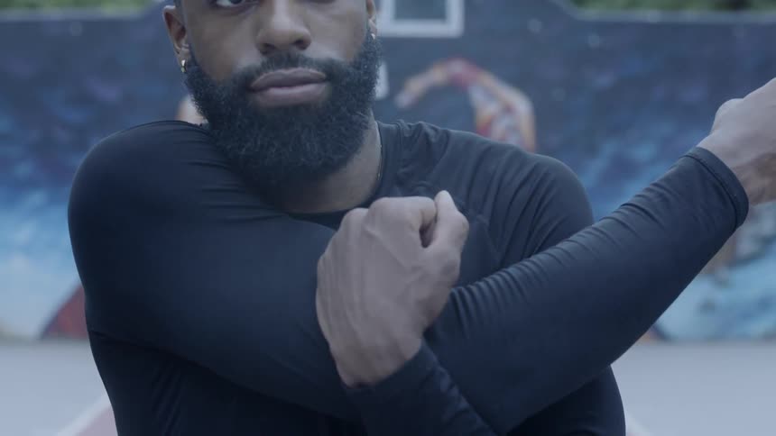 Bearded black man warms up in the basketball field on a cloudy day