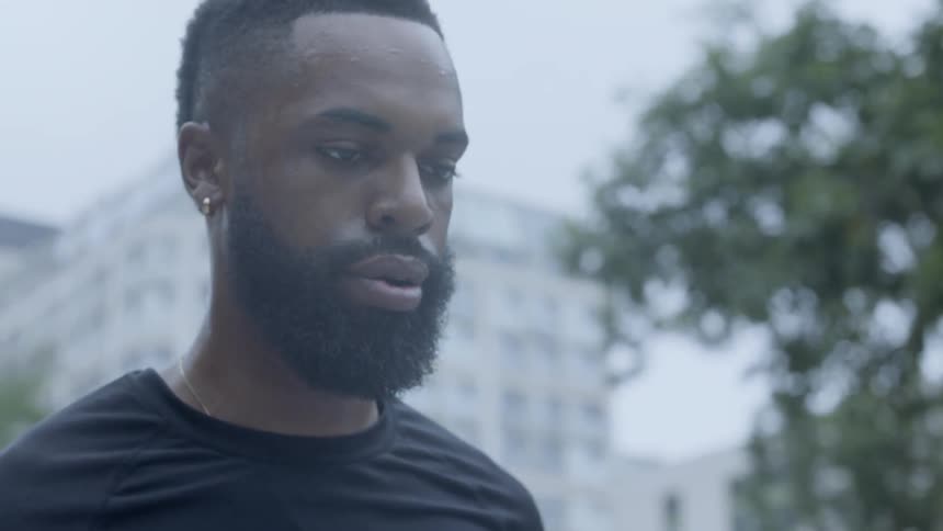 A black man standing outdoors in a city
