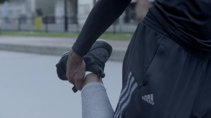Man stretches his calf on the basketball court