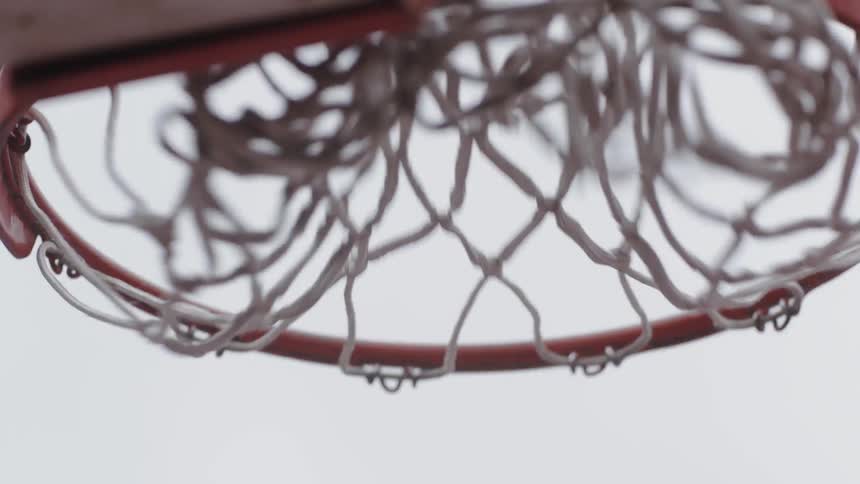 Basketball going through basketball hoop and net