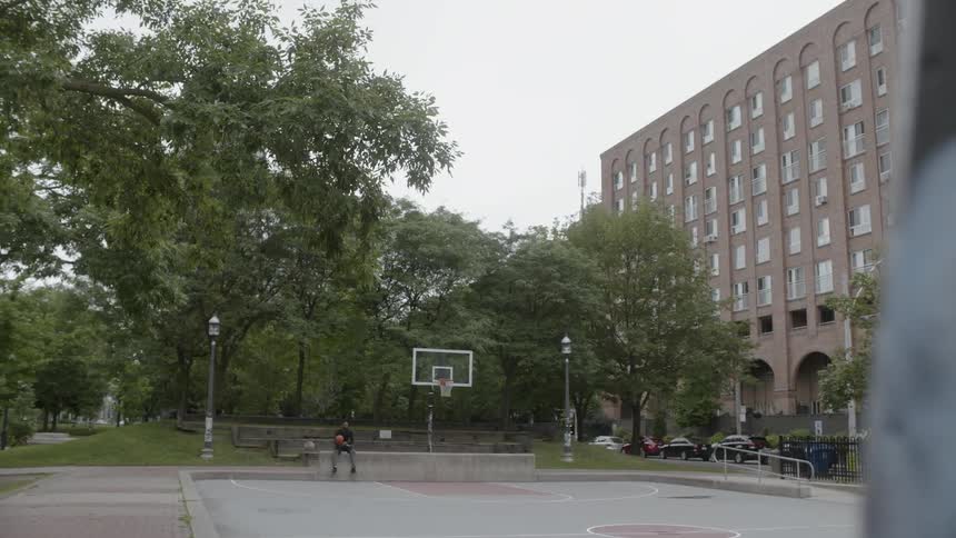 Young man sits on basketball court with ball