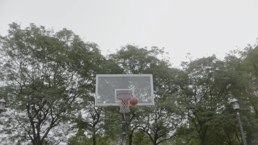 Basketball thrown at hoop then bouncing back after it missed the shot