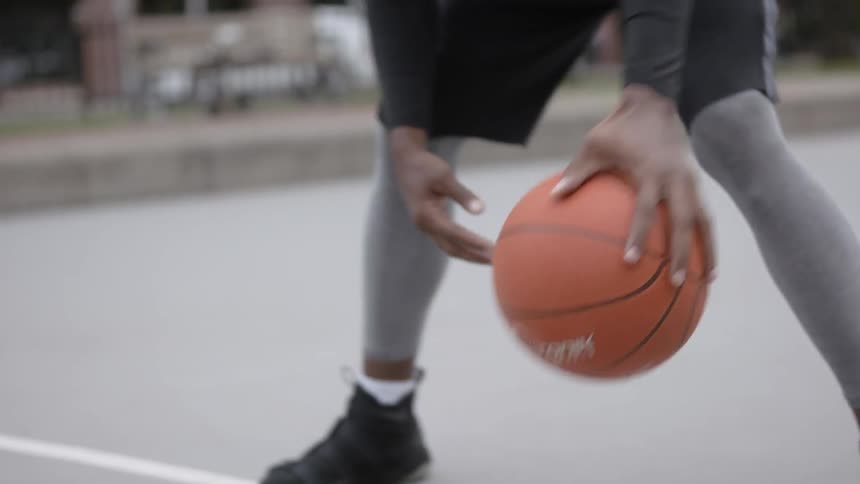 Man dribbles basketball on outdoor court