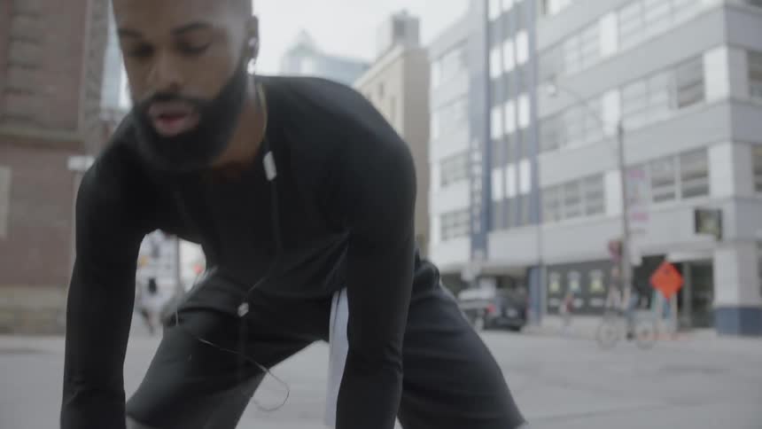 A man dribbling a basketball on a sidewalk